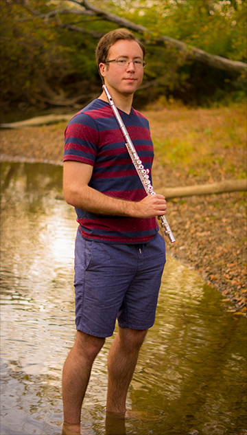 An image of David Stoeltzing standing in the water with a flute, looking majestic.